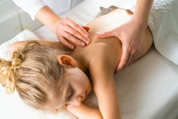 Little girl on massage, osteopathy, children massage, masseur's hands, medicine, Relax, child health